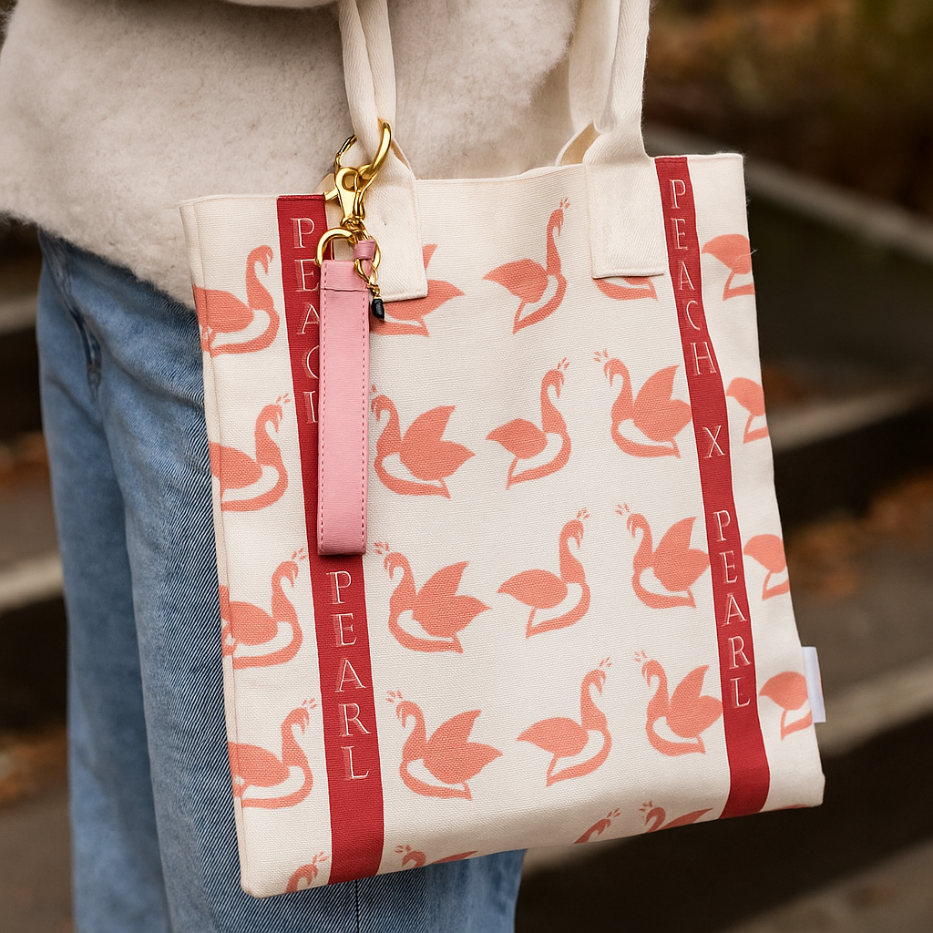 Tote bag with pink swan pattern and 'Peach x Pearl' branding.